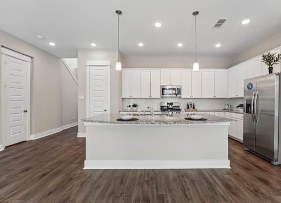 A modern kitchen with white cabinets and a central island.