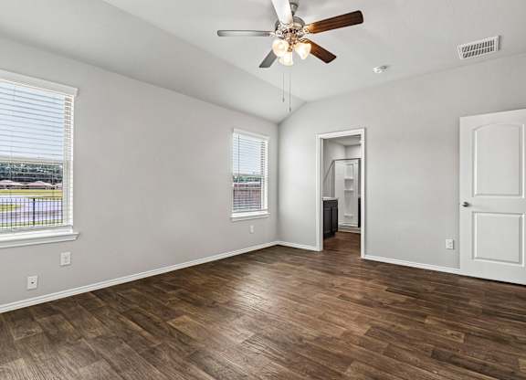 A room with a ceiling fan and wooden flooring.