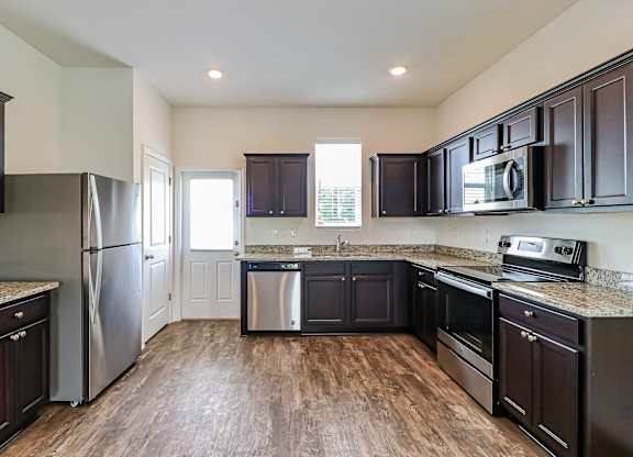 A kitchen with dark wood cabinets and stainless steel appliances.