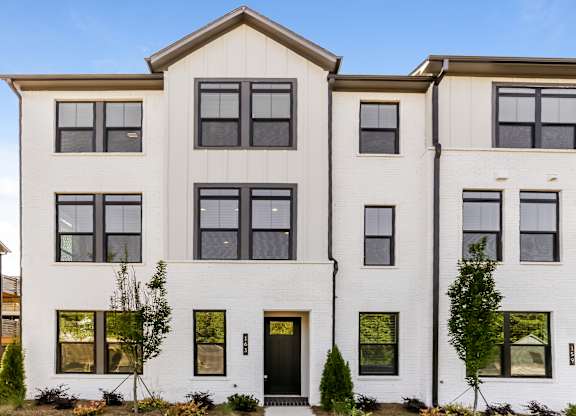 A white two-story house with black doors and windows.