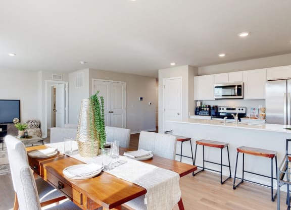 a living room and dining room with a table and chairs