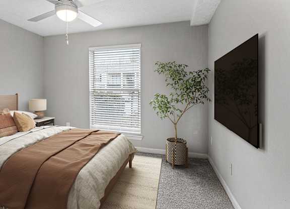 A bedroom with a bed, a ceiling fan, a window with blinds, a lamp, a plant, and a painting on the wall.