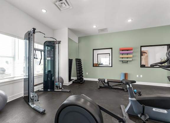 A home gym with a variety of equipment including a treadmill, weights, and a stationary bike.