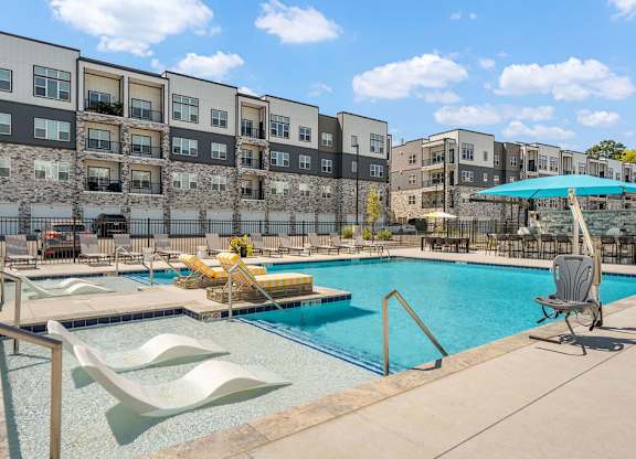 A swimming pool with a slide and a chair.