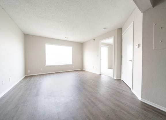 an empty living room with wood floors and white walls