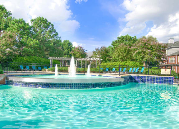 Enclave at Wolfchase Apartments in Cordova Tennessee photo of a fountain in the middle of a pool with a pergola in the background