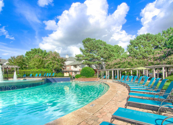 Enclave at Wolfchase Apartments in Cordova Tennessee photo of a resort style pool with chaise lounge chairs and a fountain