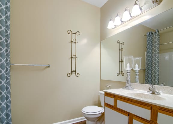 Enclave at Wolfchase Apartments in Cordova Tennessee photo of a bathroom with a toilet sink mirror and shower