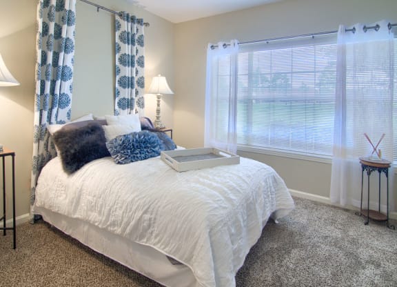 Enclave at Wolfchase Apartments in Cordova Tennessee photo of a bedroom with a bed and two windows