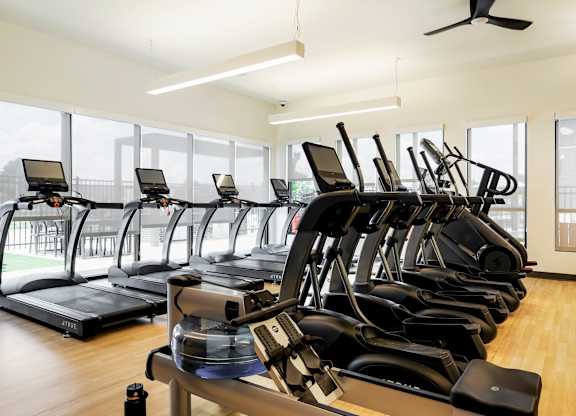 Apartments near Walmart Supercenter in Denver, CO, - Edera - Fitness Center With Treadmills, Elliptical Machines, Rowing Equipment, Large Windows, And Wood Style Flooring