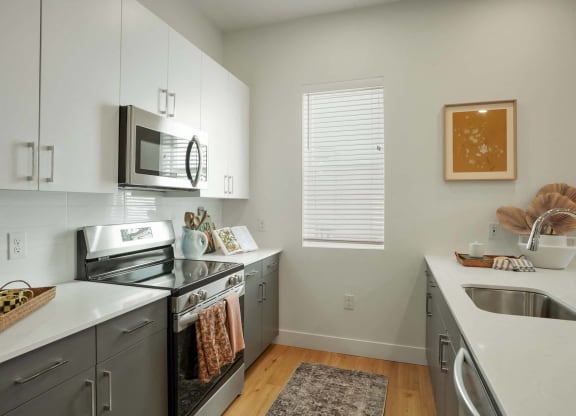 a modern kitchen with stainless steel appliances and white cabinets