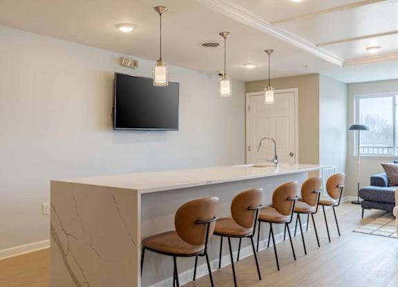 A modern living room with a bar and chairs.
