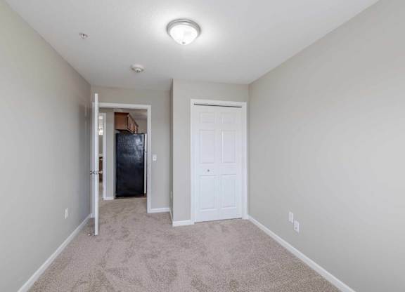 A room with a white door and a carpeted floor.