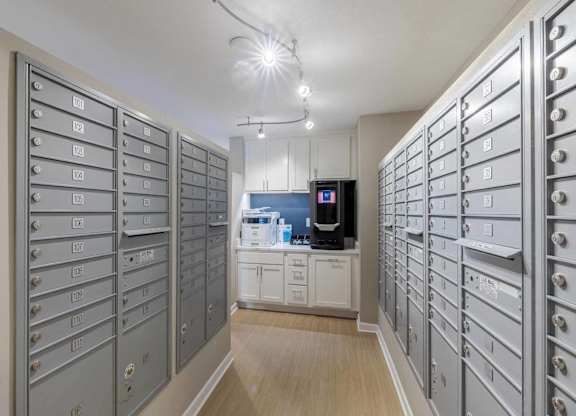 A room with a long row of mailboxes on both sides and a microwave in the middle.