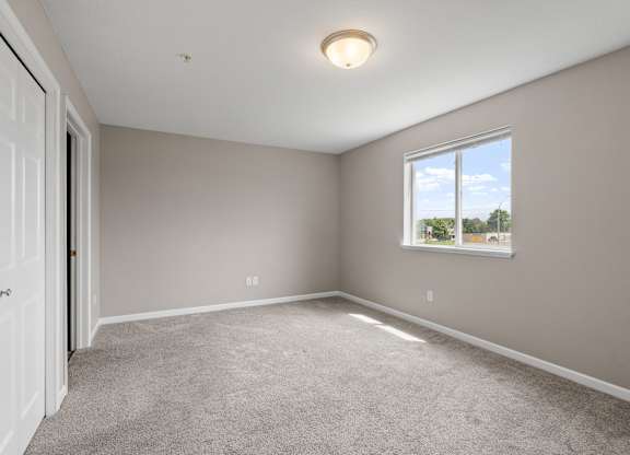 an empty room with carpet and a window