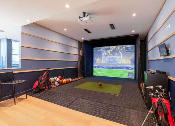 a game room with a projector screen and a ball on the floor