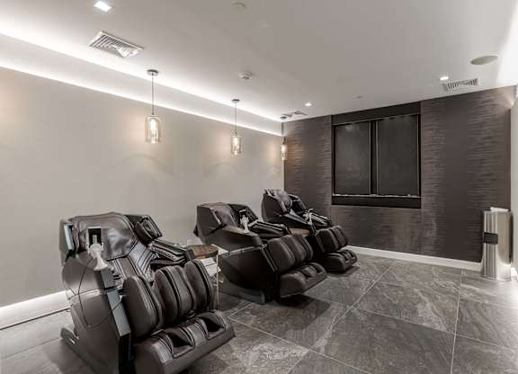 A row of black leather chairs are lined up in a room.