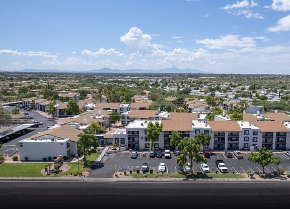 an aerial view of an apartment complex with cars parked in a parking lot