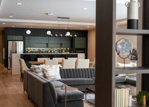 A grey sofa with a striped pillow is in the middle of a room.