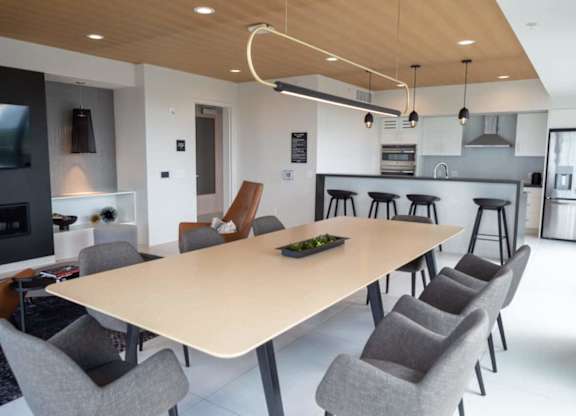 A modern dining room with a large table and chairs.