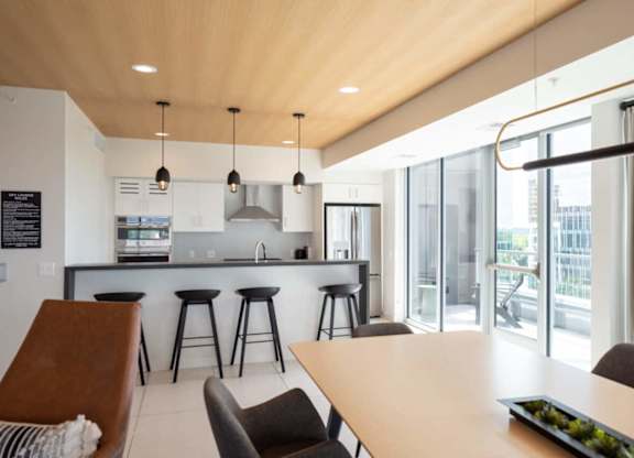 A modern kitchen with a bar area and a dining table.