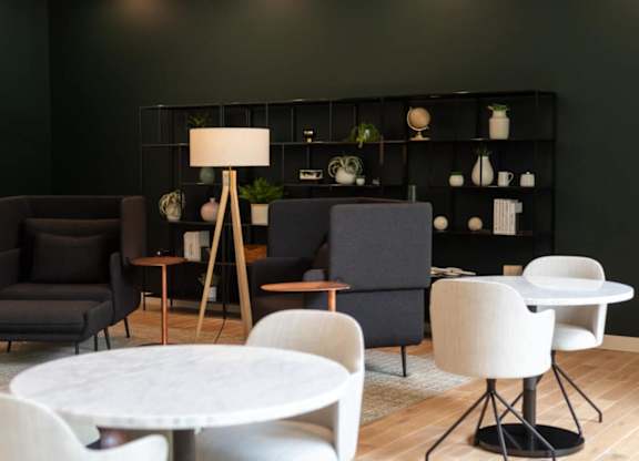 A modern living room with a white table and black and white chairs.