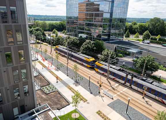 A train is passing by a modern building.