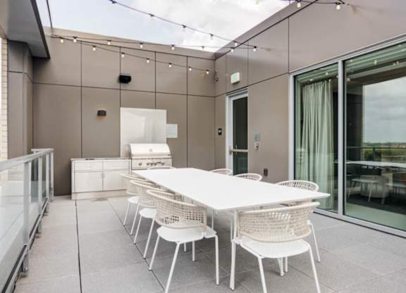 A white table and chairs are set up on a patio.
