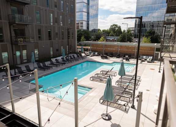 A rooftop pool with lounge chairs and umbrellas.