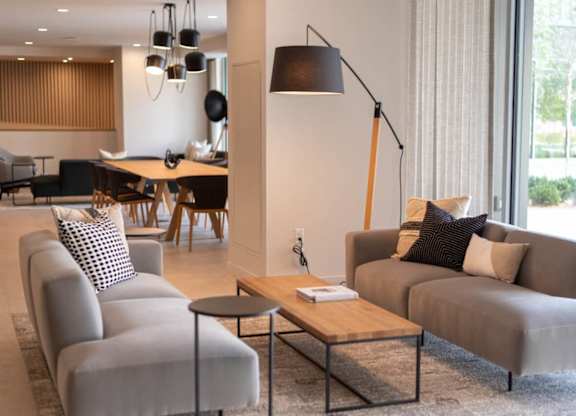 A modern living room with grey couches and a wooden coffee table.