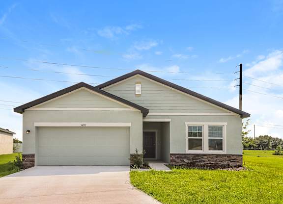 A house with a garage and a driveway in front.