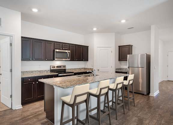 A kitchen with a granite countertop and stainless steel appliances.