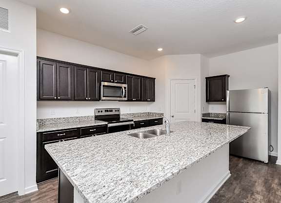 A kitchen with granite countertops and stainless steel appliances.