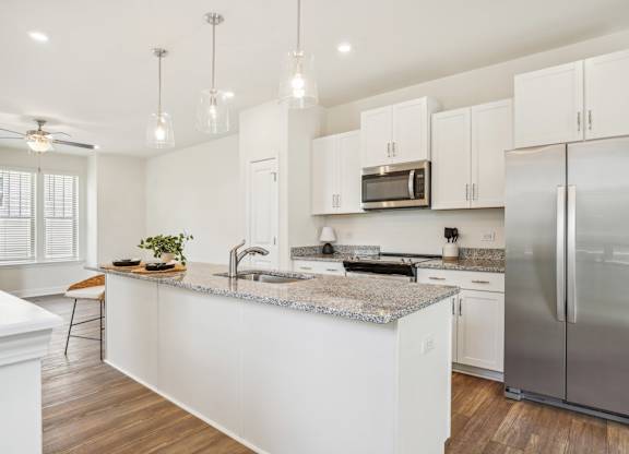 a kitchen with white cabinets and stainless steel appliances