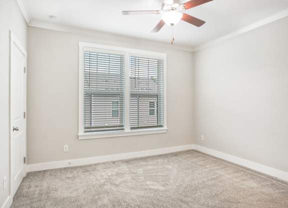 an empty room with a ceiling fan and a window