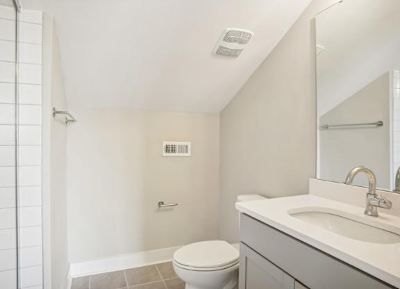 a bathroom with a toilet and a sink and a shower