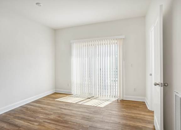 a living room with white walls and a sliding glass door