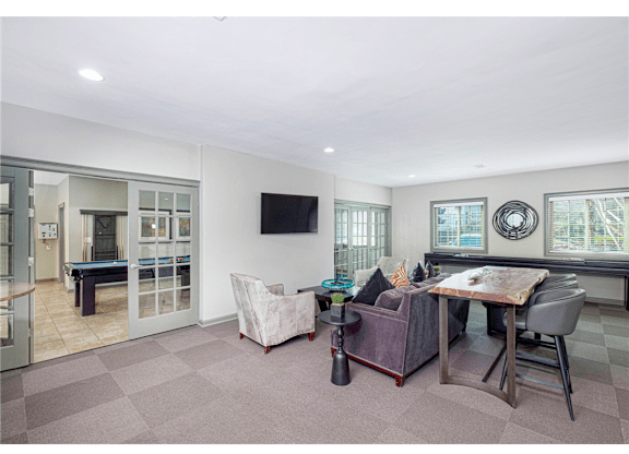 Resident clubroom with ample seating and natural light at Springdale Glen, a pet-friendly community in Clarkston, GA, near Decatur.