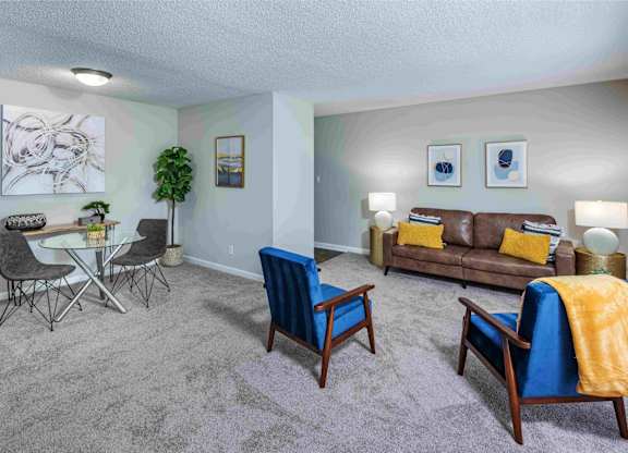 A living room with a grey carpet and furniture.