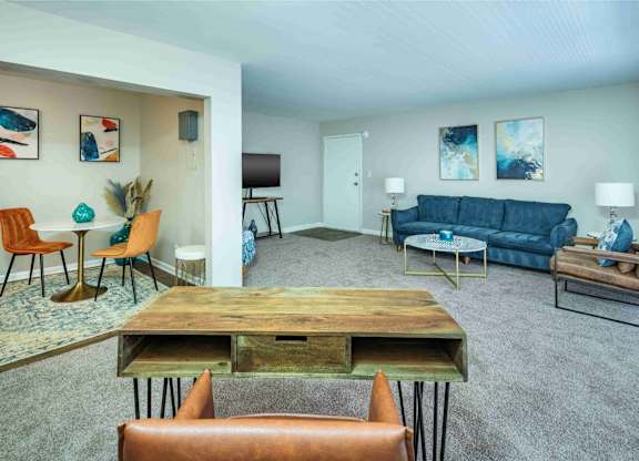 A living room with a blue couch and a wooden table.