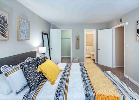 A bedroom with a bed and a striped runner on the floor.