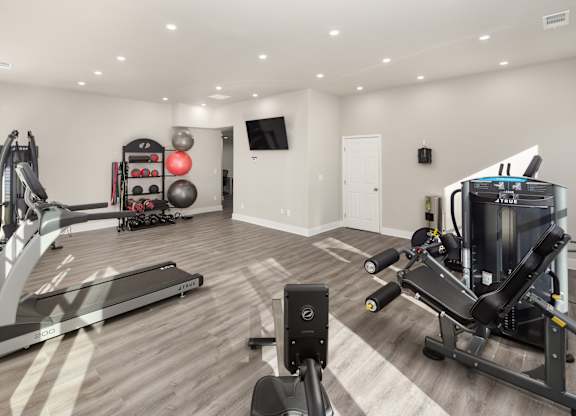 A spacious home gym with a variety of exercise equipment.