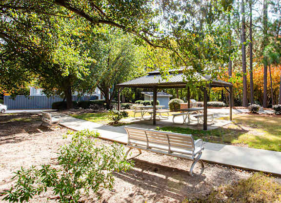 A park with a bench and a pavilion.