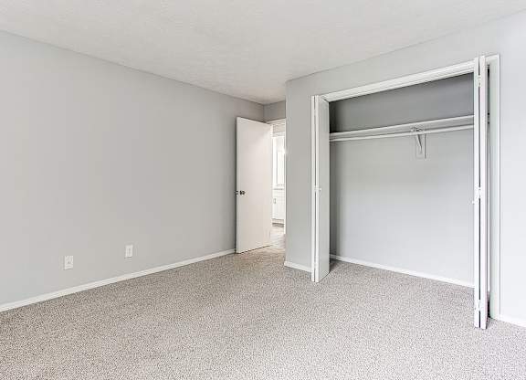 A white room with a closet and a door.