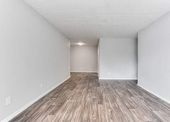 A room with wooden flooring and white walls.
