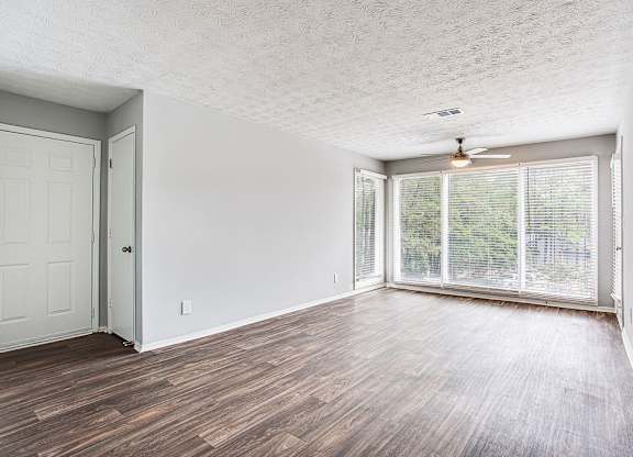 A room with a wooden floor and a sliding glass door.