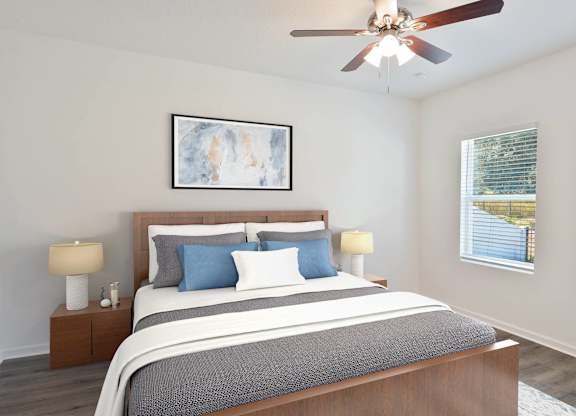 A bedroom with a large bed and a ceiling fan.
