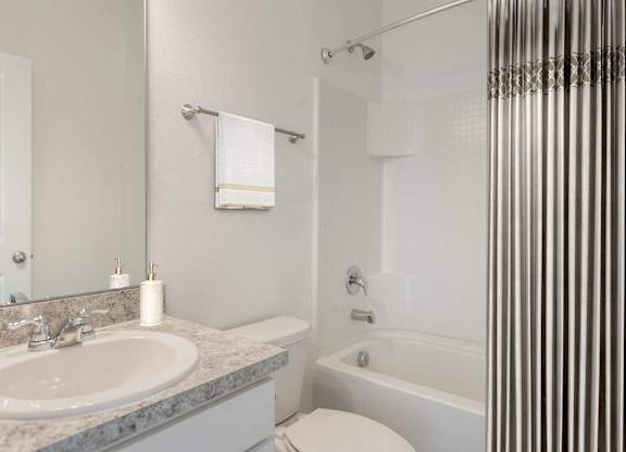 A white toilet sits next to a sink in a bathroom.