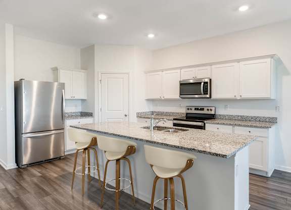 A kitchen with a granite countertop and white cabinets.