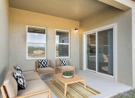 A patio with a couch, chairs, and a table.